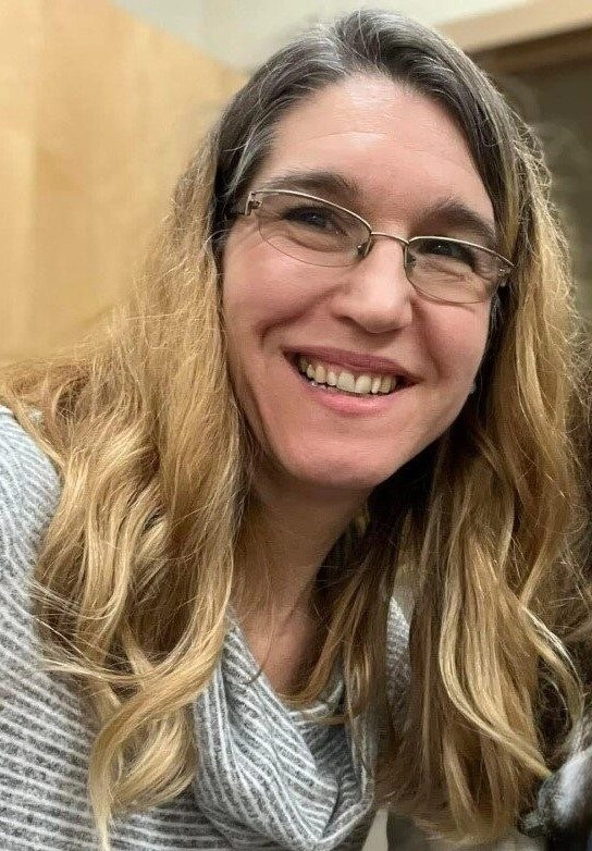 Picture of smiling woman with long brown hair and glasses